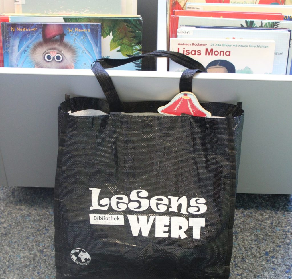Mit Büchern gefüllte Tragetasche mit dem Aufdruck "Lesenswert"