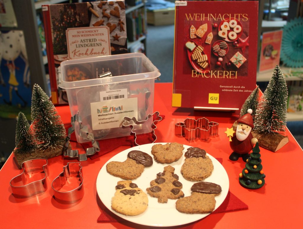 Weihnachtlich geschmückter Tisch mit Keksen und Ausstechformen